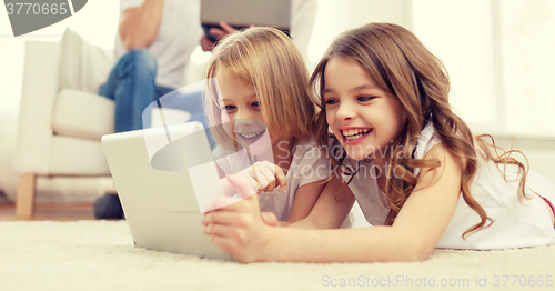 Image of smiling sister with tablet pc and parents on back