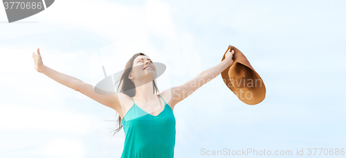 Image of girl with hands up on the beach