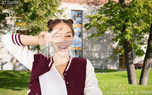 Image of happy smiling teenage girl showing peace sign