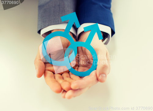 Image of close up of happy male gay couple with love symbol