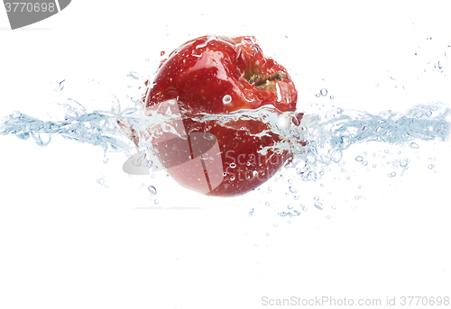 Image of apple falling or dipping in water with splash