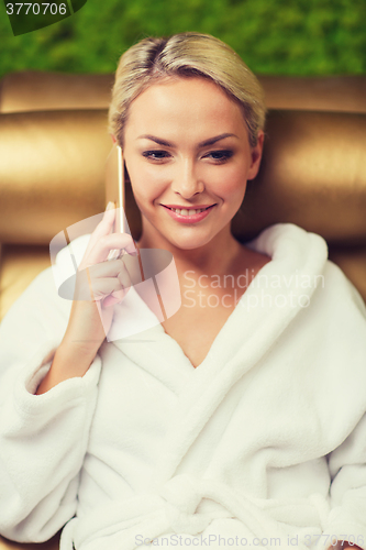 Image of beautiful young woman with smartphone at spa