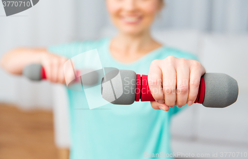 Image of close up of woman exercising with dumbbell at home