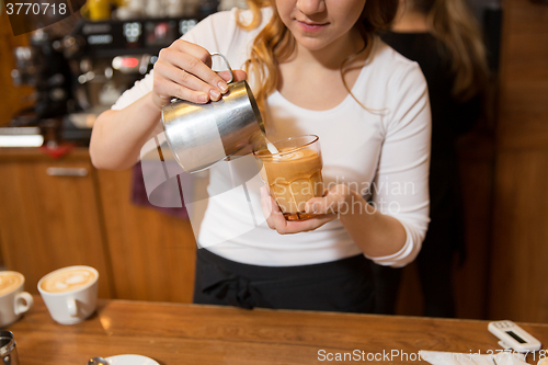 Image of close up of woman making coffee at shop or cafe