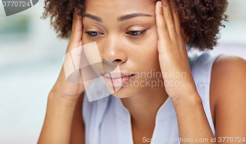 Image of close up of african young woman touching her head