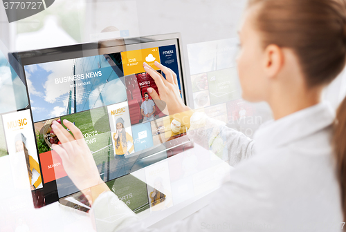 Image of woman with web pages on touchscreen in office