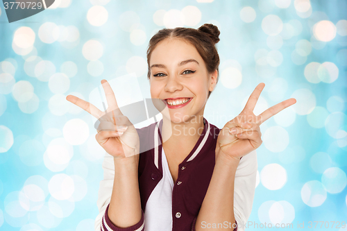 Image of happy smiling teenage girl showing peace sign