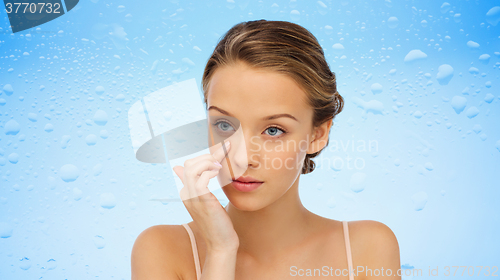 Image of young woman applying cream to her face