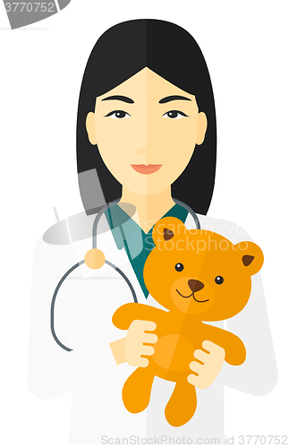 Image of Pediatrician holding teddy bear.