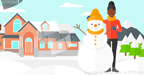 Image of Woman posing near snowman.