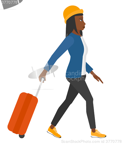 Image of Woman walking with suitcase.