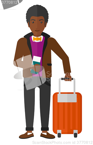 Image of Man standing with suitcase and holding ticket.