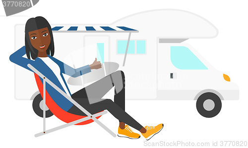 Image of Woman sitting in front of motorhome.