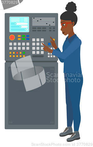 Image of Engineer standing near control panel.