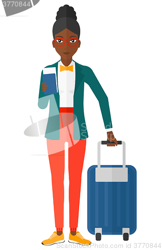 Image of Woman standing with suitcase and holding ticket.