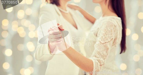 Image of close up of happy married lesbian couple dancing