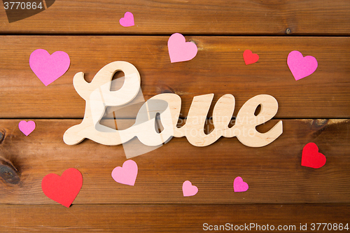 Image of close up of word love with red paper hearts