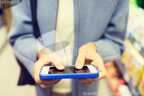Image of close up of woman with smartphone in market