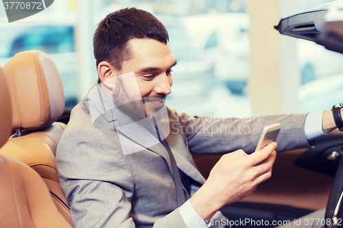 Image of happy man sitting in car at auto show or salon