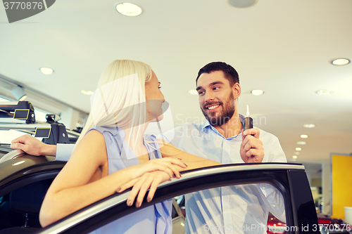 Image of happy couple buying car in auto show or salon