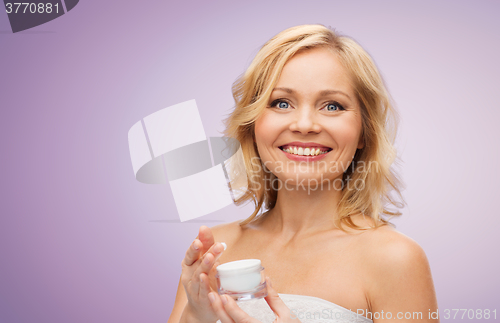 Image of happy middle aged woman with cream jar