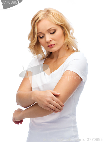 Image of unhappy woman suffering from pain in hand