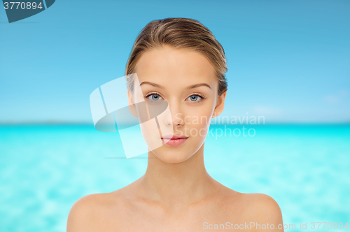 Image of young woman face over blue sea nd sky