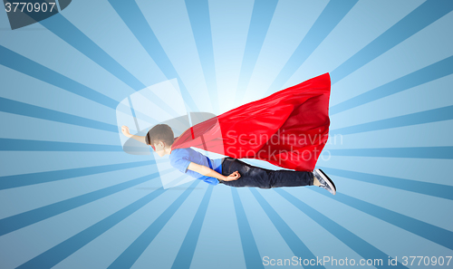 Image of boy in red superhero cape and mask flying on air