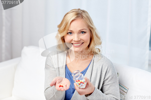 Image of happy middle aged woman with medicine at home