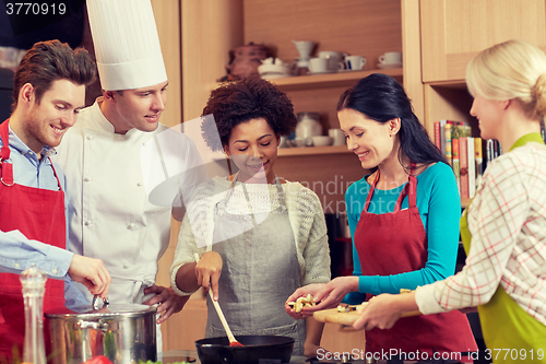 Image of happy friends and chef cook cooking in kitchen