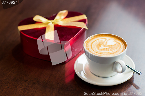 Image of close up of gift box and coffee cup on table