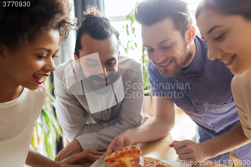 Image of happy business team eating pizza in office