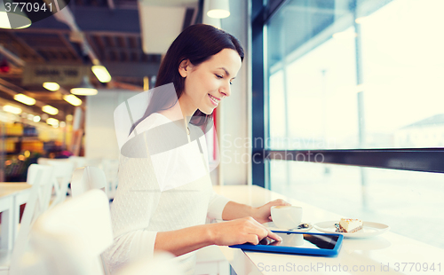 Image of smiling woman with tablet pc and coffee at cafe