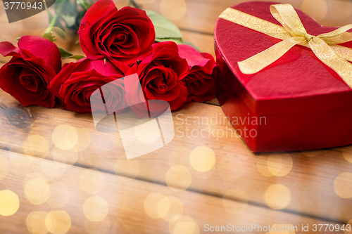 Image of close up of heart shaped gift box and red roses