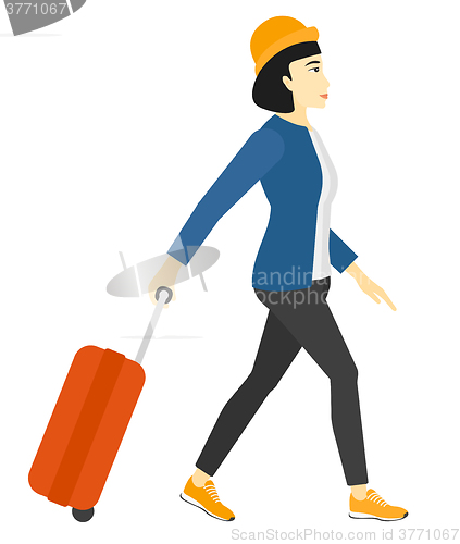 Image of Woman walking with suitcase.