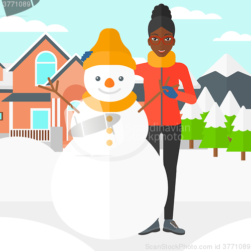 Image of Woman posing near snowman.