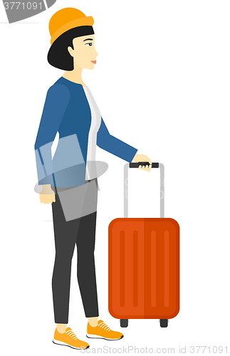 Image of Woman standing with suitcase.