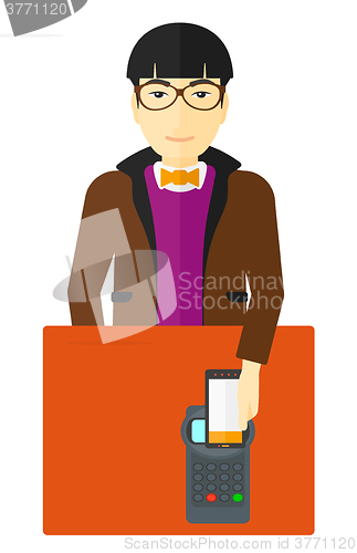 Image of Man paying using smartphone.