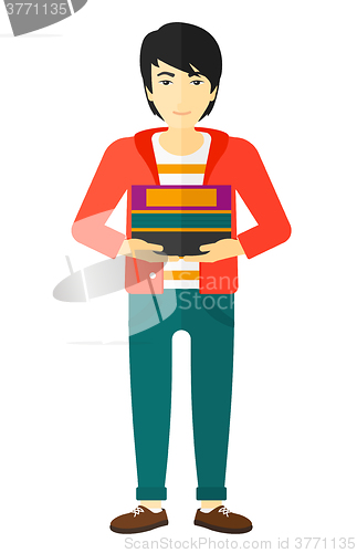 Image of Man holding pile of books.