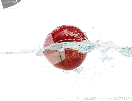 Image of apple falling or dipping in water with splash