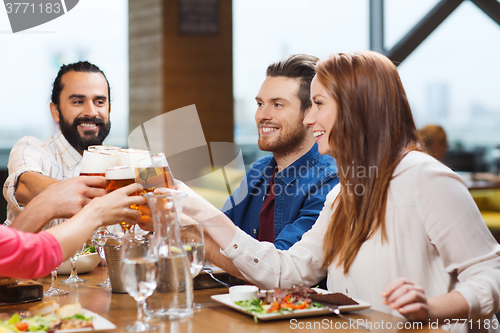 Image of friends dining and drinking beer at restaurant