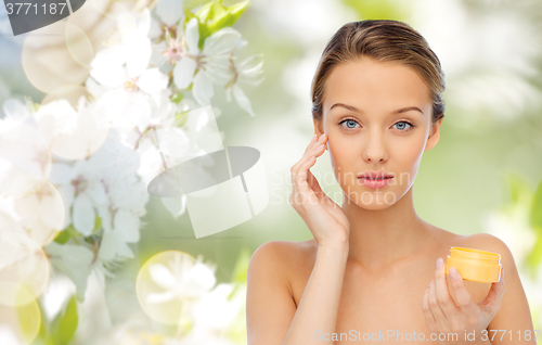 Image of young woman applying cream to her face