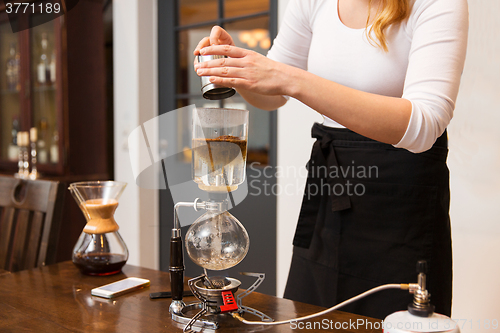 Image of close up of woman with siphon coffee maker and pot