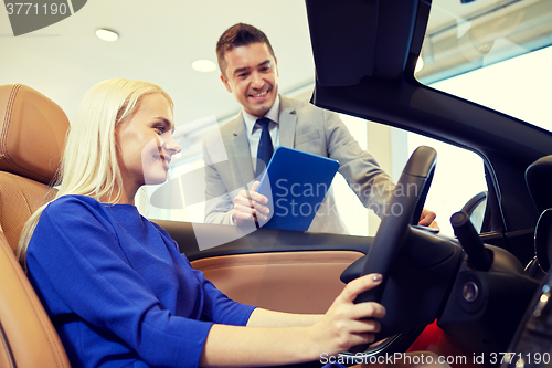 Image of happy woman with car dealer in auto show or salon