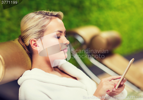 Image of beautiful young woman with smartphone at spa