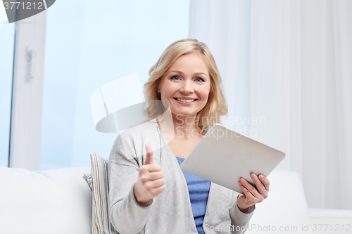 Image of happy woman with tablet pc showing thumbs up