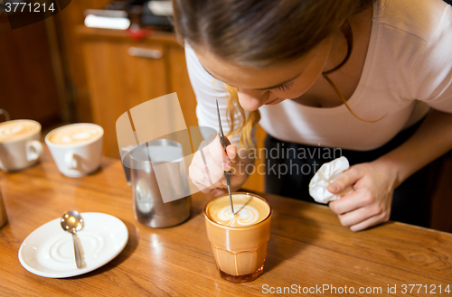 Image of close up of woman making coffee at shop or cafe