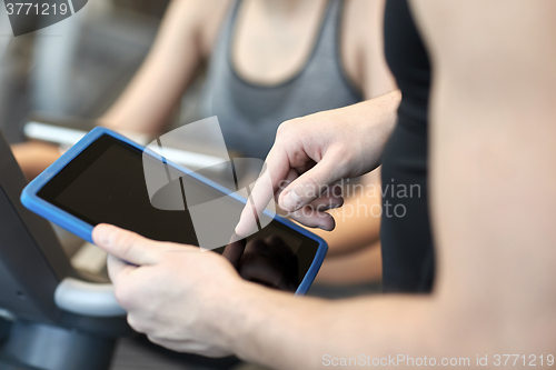 Image of close up of trainer hands with tablet pc in gym