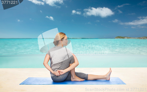 Image of woman making yoga in twist pose on mat