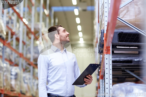 Image of happy businessman with clipboard at warehouse